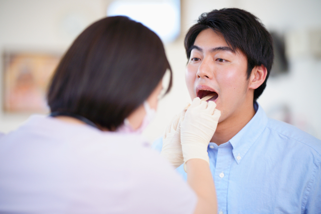 舌を診てもらっている男性